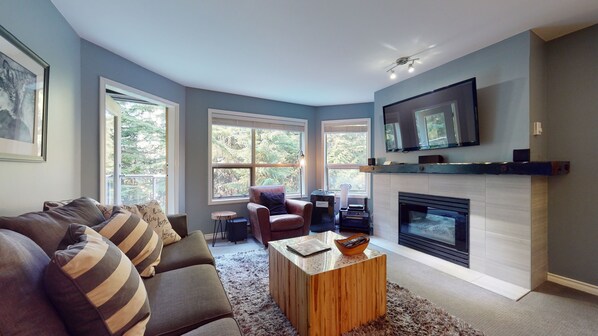 Living room with large windows looking out to the forest