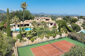 View of house with pool and tennis court