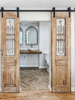 Beautiful vintage barn doors with a partial view of the master bathroom that is stunning remodeled!