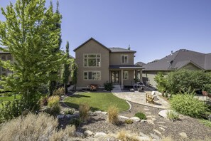 Back yard patio/ entertaining space with seating and a grill.