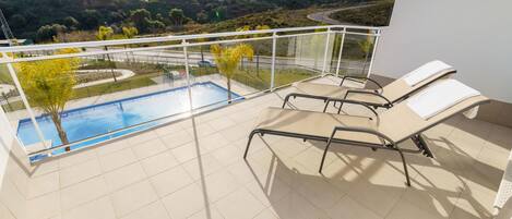 Gran terraza cubierta con vistas a la piscina