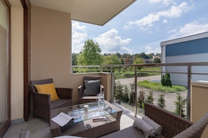 Spacious balcony with outdoor furniture.