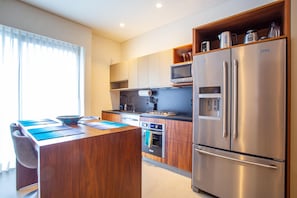 The kitchen is equipped with a full size refrigerator, stove, oven and microwave