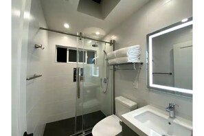 The bathroom with a skylight. The hands-free smart toilet automatically flushes.