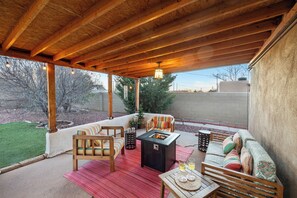 Our lovely covered back patio w/ conversation furniture, firepit & fully fenced