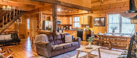 Cabin main level has open floor plan with kitchen, living and dining area. Vaulted ceilings.