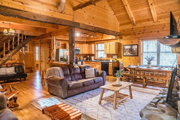 Cabin main level has open floor plan with kitchen, living and dining area. Vaulted ceilings.