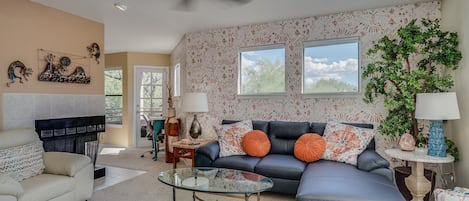 Living room area with loads of light, leather furniture, and designer touches