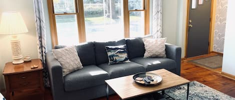 Large picture window overlooks the front porch on a quiet residential street