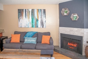 Queen-sized sleeper sofa by the fireplace & TV makes for a relaxing time