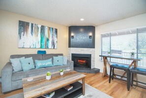 Renovated living room with a stone fireplace, electric insert & red rock views