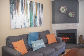 Cozy up by the fireplace while watching TV. The sofa is a queen-sized sleeper.