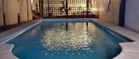 Pool at night showing garden seating area.