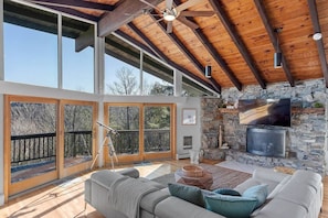 Second Floor living room with Lake and mountain views, 15 feet ceiling, plenty of natural light, and a big deck.
