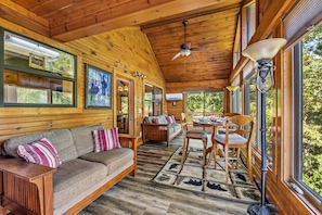 Large sunroom with big windows, comfortable seating, lots of natural light and mountain views.