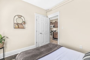 Cozy bedroom with mid century modern decor and closet for clothes storage.