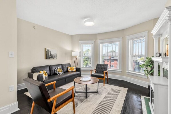 Step into the living room with ample natural light and electric fireplace.