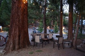 Shared firepit area has a bar top, chairs, firepit, and charcoal BBQ's