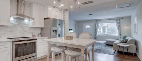 There is High End Stainless Steel Appliances in the Kitchen And a Beautiful White Stone Backsplash