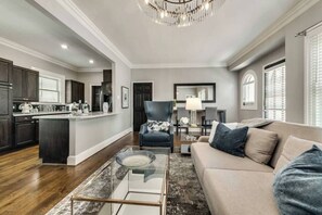The open kitchen is fully equipped for meal preparation, while the cozy living room offers a comfortable space to relax and unwind.