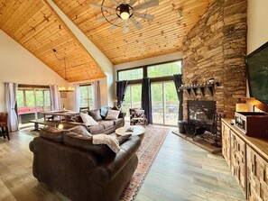 Cozy living room with wood burning fireplace and beautifully tall ceilings