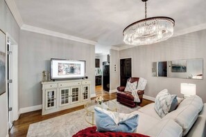 A comfortable living room blending modern elegance, featuring a 65" smart TV for the perfect space to relax and unwind.