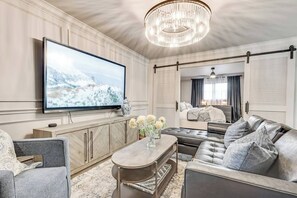 A spacious, beautifully decorated living room featuring a large smart TV, ideal for both relaxing and entertaining guests.