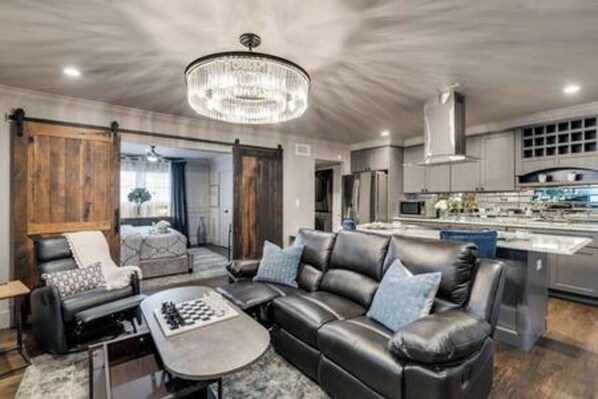 A spacious, open-concept living room featuring a large Smart TV with both Android TV and Roku for endless entertainment options.