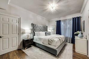 Ensuite Bedroom #2 features a comfortable queen bed, light and airy decor, and blackout curtains to ensure a restful night's sleep.