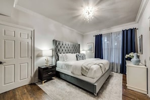 Ensuite Bedroom #2 features a comfortable queen bed, light and airy decor, and blackout curtains to ensure a restful night's sleep.
