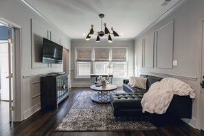 Living room with comfy sectional sofa and Smart TV. There is also a dedicated desk to stay caught up on work.