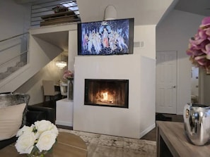 Large smart TV, stairs to the left leading up to the loft and second bed.