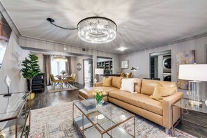 Spacious living room with a roomy leather sectional and plenty of seating, plus a large Smart TV for ultimate relaxation and entertainment.