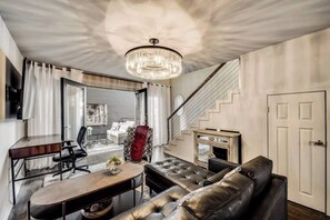 Spacious living room with a roomy leather sectional and plenty of seating, plus a large Smart TV for ultimate relaxation and entertainment.