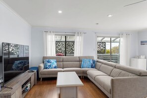 Spacious upstairs living room with large TV