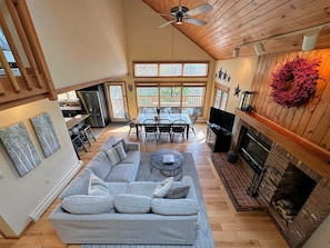 Living Room with TV, wood-burning fireplace, dining area and attached kitchen