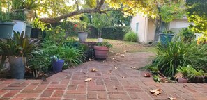 Patio with barbecue and seating area overlooking shaded enclosed back yard