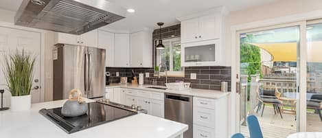 Welcome to your home away from home in Arvada! The upgraded kitchen is a cook's delight–brand-new appliances, modern cabinetry, and center cook top with ceiling mounted hood fan.