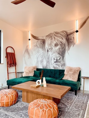An oversized statement mural accents the beautifully curated living room.