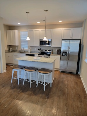 Open kitchen off the living room stocked with the basic kitchen necessities.