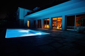 Fachada e piscina à noite