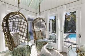Swinging in a cool sun room overlooking a heated plunge pool