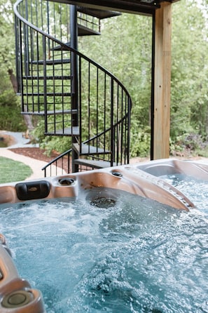 Fun spiral staircase leading to the upper deck located right next to the steaming hot tub which is located right outside the glass garage door.