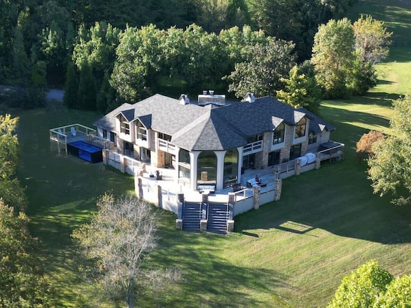 Expansive deck with heated pool, hot tub, bar top railings and grand center staircase