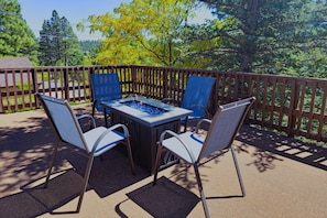 Cozy up around the fire table, perfect for s'mores and stories, while enjoying the pines.