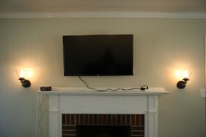 Living Room showing Roku TV, wall mounted lamps, and fireplace