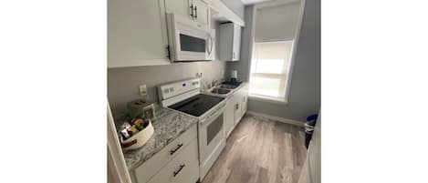 Kitchen with microwave, full size fridge, stove, toaster and Keurig coffee maker