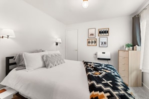 This queen size bedroom has access to the side yard with a table and chairs.
