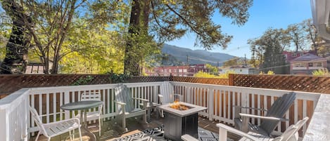 Wood deck in the garden features a fire pit and plenty of seating.