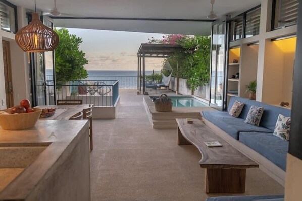 open concept living, dining and kitchen overlook private terrace and ocean view